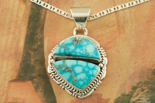  Genuine Turquoise Mountain Mine Stones set in Sterling Silver Pendant. Free 18" Sterling Silver Chain with Purchase of Pendant. Created by Navajo Artist Lucy Valencia. Signed L. J. by the artist. The Turquoise Mountain Mine is located in the Mineral Park Mining District, Mohave County, Arizona. Although Turquoise Mountain is located near the Kingman Turquoise Mine it is considered a classic mine in its own right because the Turquoise is so different in appearance. It is also known as "Old Man Turquoise". 